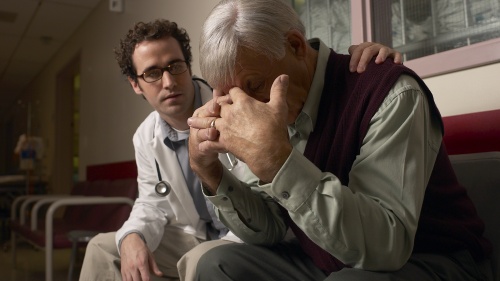 A doctor consoling a person who is grieving. 