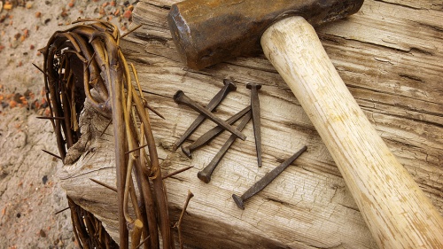 A crown of thorns, nails, hammer and post.