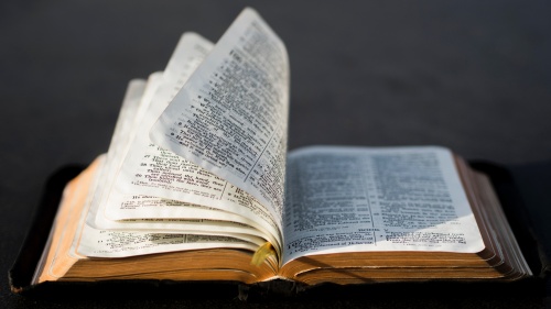 An open Bible laying on a table.
